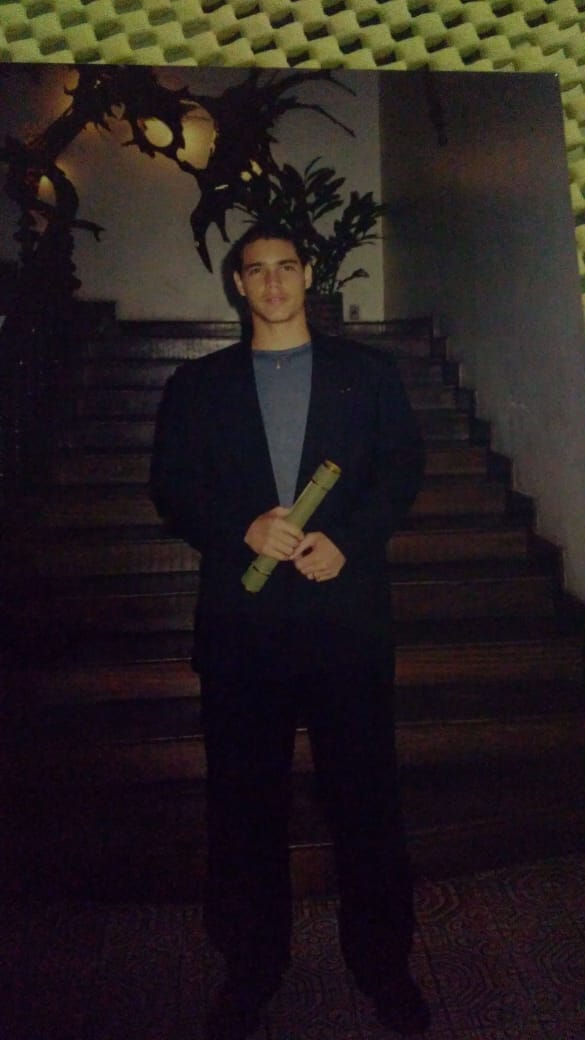 Marco Severiano em sua formatura, segurando o diploma